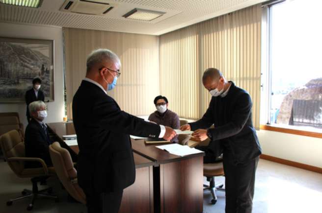 町長へ報告書を提出する深山委員長の画像